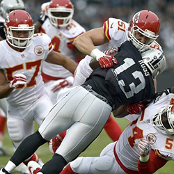 american football player is tackled by players during a game.