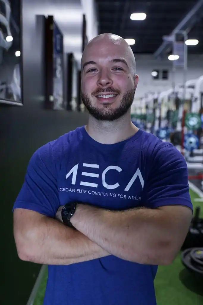 a man in a blue shirt smiling at the camera.