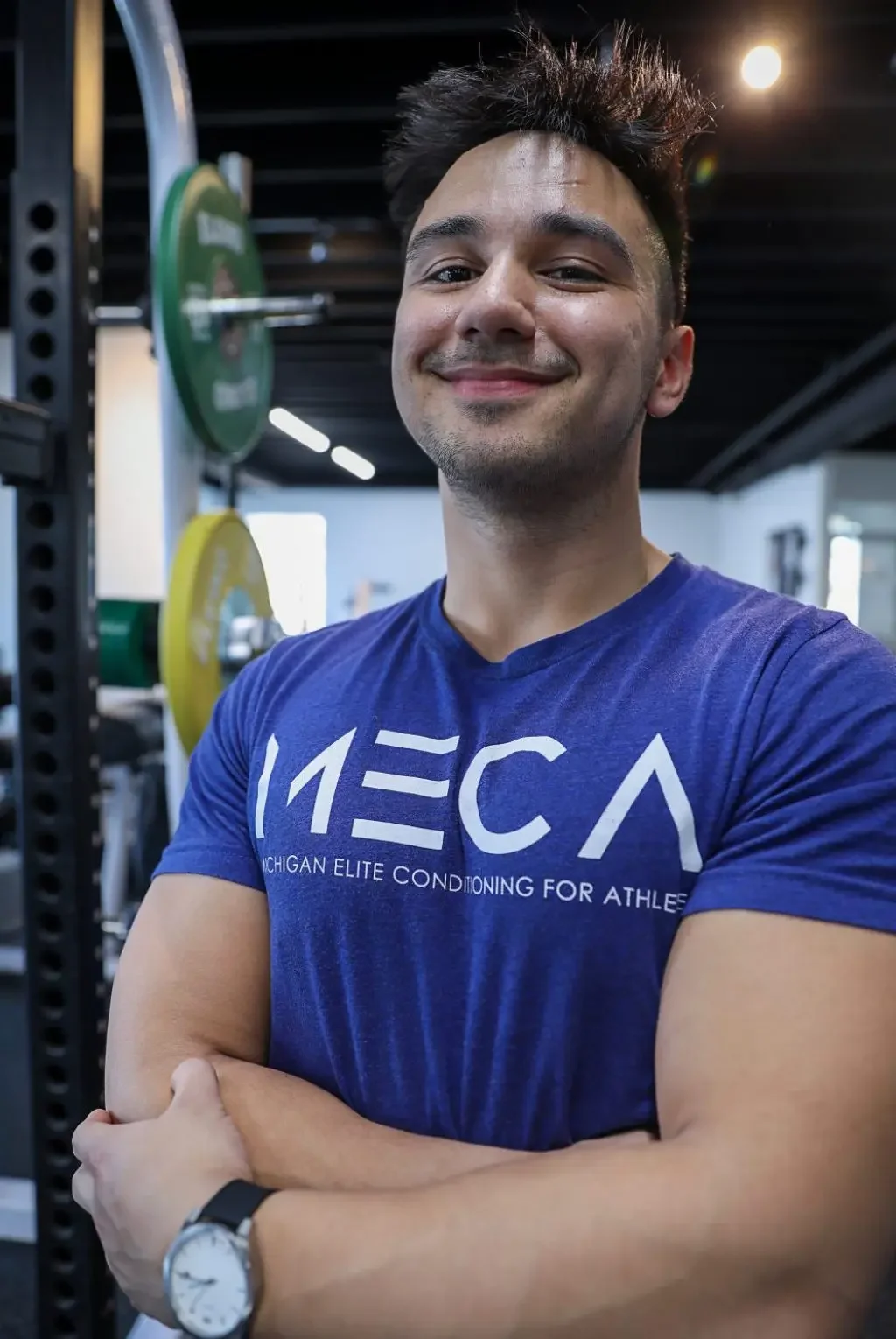 a man in a blue shirt smiling at the camera